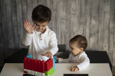İki mutlu bebek oyuncak bloklarla oynama.