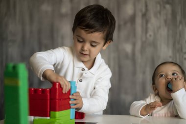 İki mutlu bebek oyuncak bloklarla oynama.