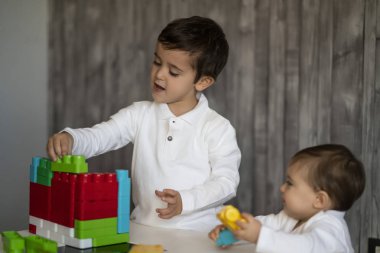 İki mutlu bebek oyuncak bloklarla oynama.