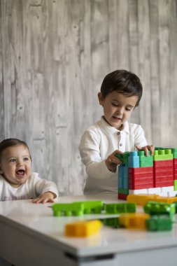 İki mutlu bebek oyuncak bloklarla oynama.