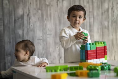 İki mutlu bebek oyuncak bloklarla oynama.