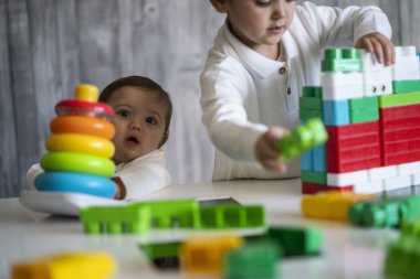 İki mutlu bebek oyuncak bloklarla oynama.