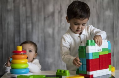 İki mutlu bebek oyuncak bloklarla oynama.