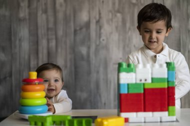 İki mutlu bebek oyuncak bloklarla oynama.