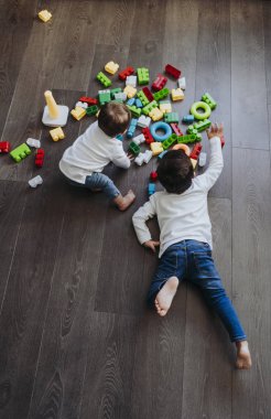 İki mutlu bebek oyuncak bloklarla oynama.