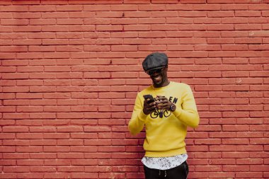 Cep telefonunu kullanan yakışıklı afro adam portresi.