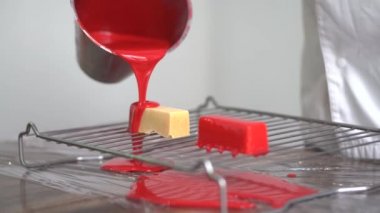 Kırmızı krem plaka üzerinde lezzetli kek üzerine dökülen el