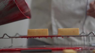 Kırmızı krem plaka üzerinde lezzetli kek üzerine dökülen el