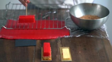 Kırmızı krem plaka üzerinde lezzetli kek üzerine dökülen el