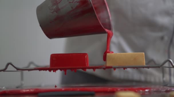 Hand Gießt Rote Sahne Auf Leckeren Kuchen Auf Teller — Stockvideo