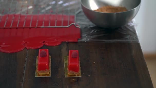 Hand Gießt Rote Sahne Auf Leckeren Kuchen Auf Teller — Stockvideo