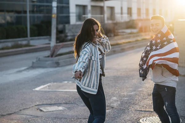 Sokaklarda Amerikan bayrağı taşıyan bir grup mutlu arkadaş.