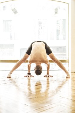 Ahşap zemin üzerinde yoga yapan bir adam