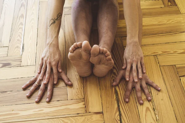 Een man en een vrouw die yoga op de houten vloer doen — Stockfoto