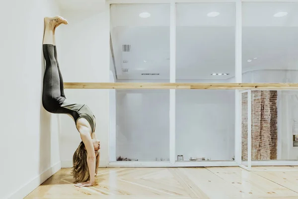 Жінка, яка займається йогою на дерев'яній підлозі — стокове фото
