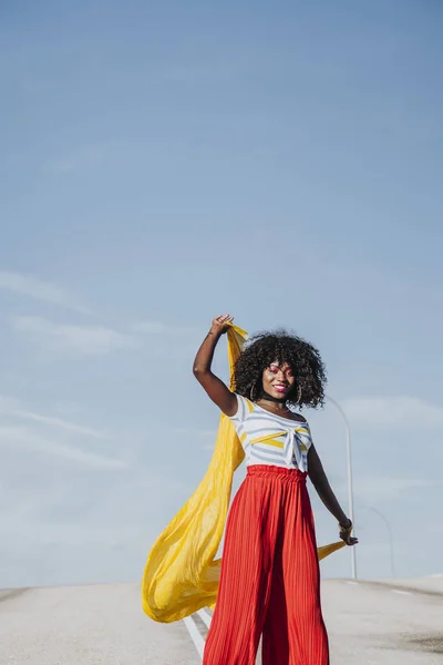 Afro woman with a yellow coloured scarf on the street — Stock Photo, Image