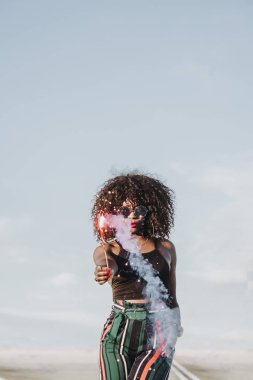 Maytap ve güneş gözlüklü genç afro kadın.