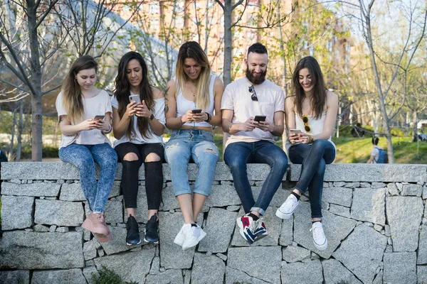 Група з п'яти друзів на вулиці зі смартфоном — стокове фото