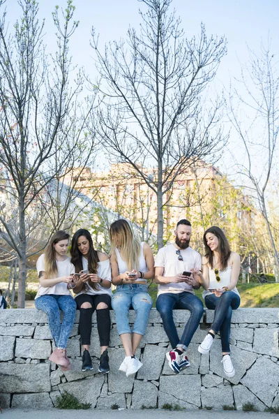 Grupul de cinci prieteni pe stradă cu smartphone — Fotografie, imagine de stoc
