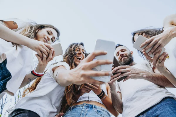 Grupo de cinco amigos na rua com smartphone — Fotografia de Stock