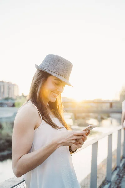 Mulher feliz mensagens de texto no telefone inteligente na rua — Fotografia de Stock