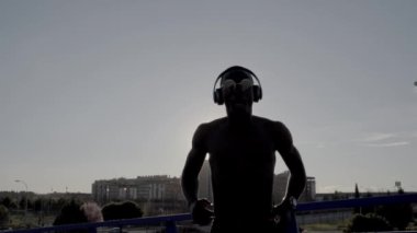 Güneşli bir günde dans Afrika adam. Bazı kulaklık kullanmak