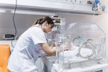 Kadın doktor muayene yenidoğan bebek içinde inkübayör