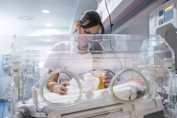 Female doctor examining newborn baby in incubator — Stock Photo, Image