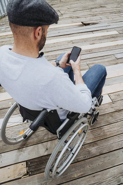 Retrato de homem em cadeira de rodas usando telefone celular — Fotografia de Stock