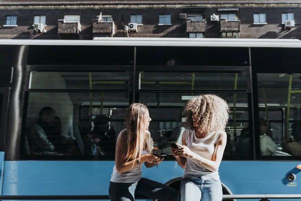 Mulheres bonitas usando um celular na rua. — Fotografia de Stock