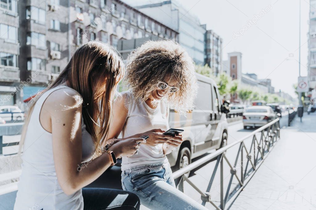 Beautiful women using a mobile in the Street.