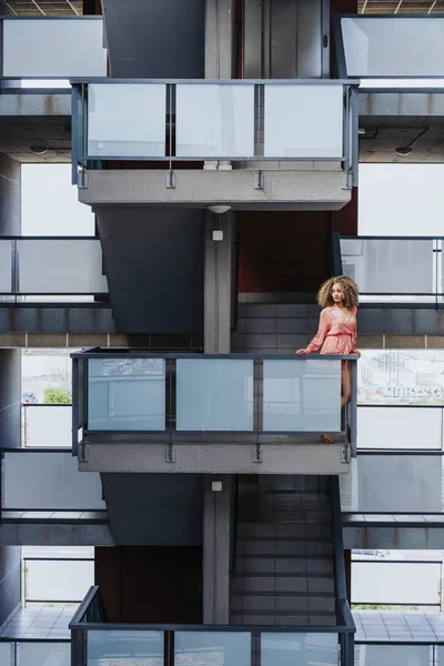 Afro woman who is crop up to the window of the building — Stock Photo, Image