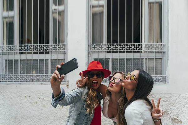 Trzy dziewczyny interakcji ze smartfonem — Zdjęcie stockowe