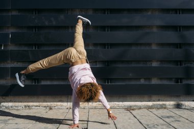Genç kadın breakdancer, sokakta breakdance performans ters hareket.