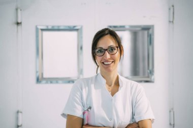 Hastane koridorunda kesişen elleri ile üniformalı kadın doktor