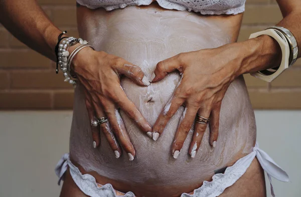 Крупним планом вагітна жінка наносить крем на живіт — стокове фото