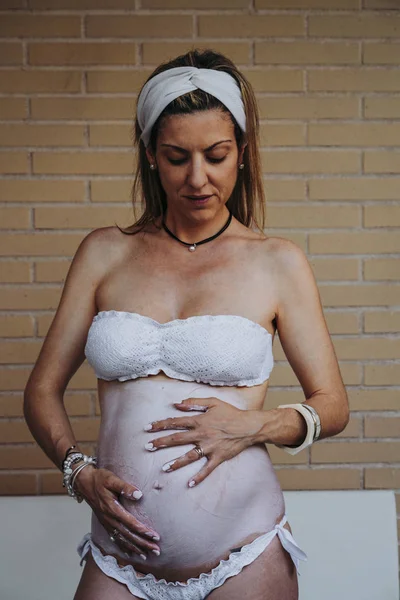 Close-up de mulher grávida aplicando creme na barriga — Fotografia de Stock