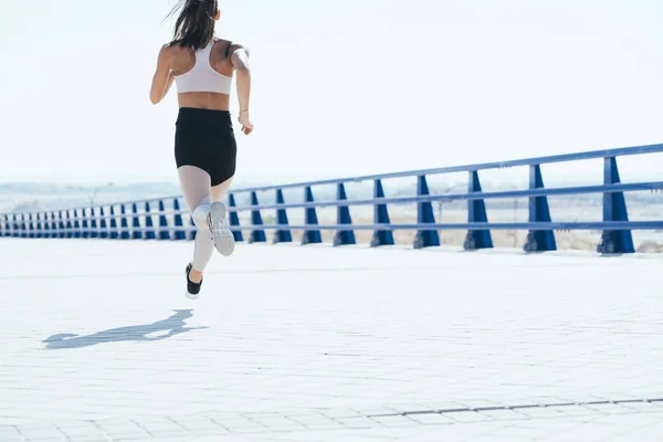 Tiro ao ar livre de uma jovem mulher em forma correndo . — Fotografia de Stock