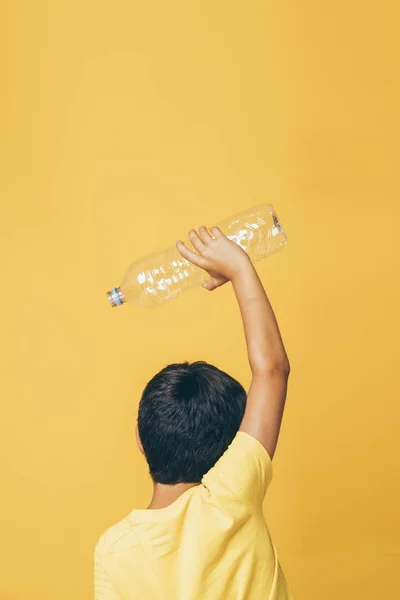 Mão do menino segurando uma garrafa de plástico para reciclagem — Fotografia de Stock