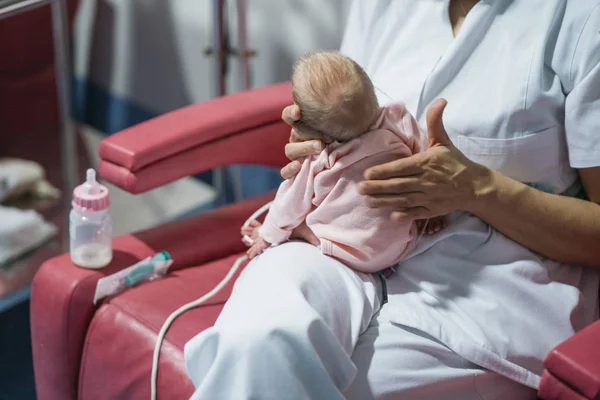 Γυναίκα γιατρός που εξετάζει νεογέννητο μωρό μετά το γεύμα. Νυχτερινή βάρδια — Φωτογραφία Αρχείου