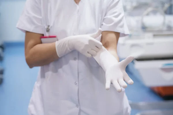 Женщина-врач работает, надевая медицинские перчатки — стоковое фото