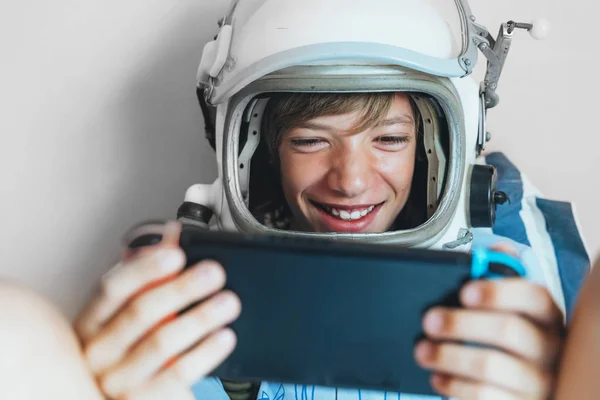 Kid lying on couch and playing with a video game console at home — Stock Photo, Image