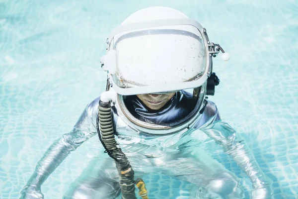 Niño con casco de astronauta en el agua —  Fotos de Stock