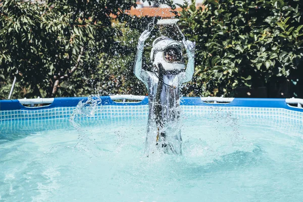 Little boy with astronaut helmet in the water