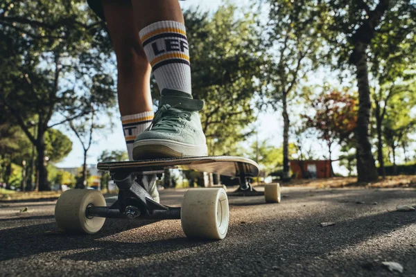 Legs of teenage girl with longboard — Stock Photo, Image