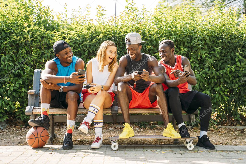 Group of friends using mobile phone at the street