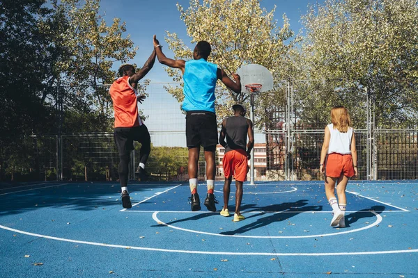 Невпізнавані друзі-підлітки весело грають у баскетбол — стокове фото