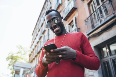 Sokakta cep telefonu kullanan Afrikalı bir adam.