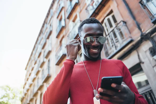 African man listening music in the street — Stock Photo, Image