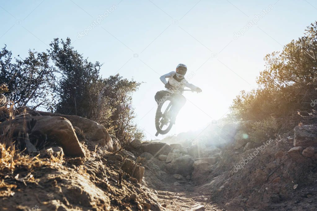 Mountain bike downhill rider in action at sunset
